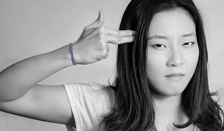 Person pointing fingers at head